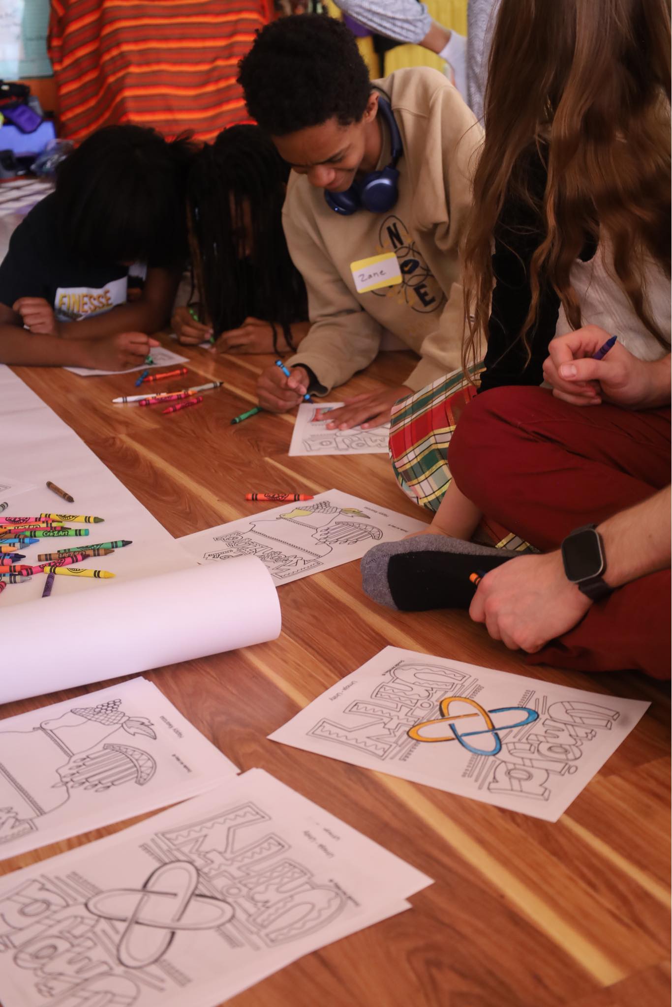 Youth coloring Kuumba artwork at community event